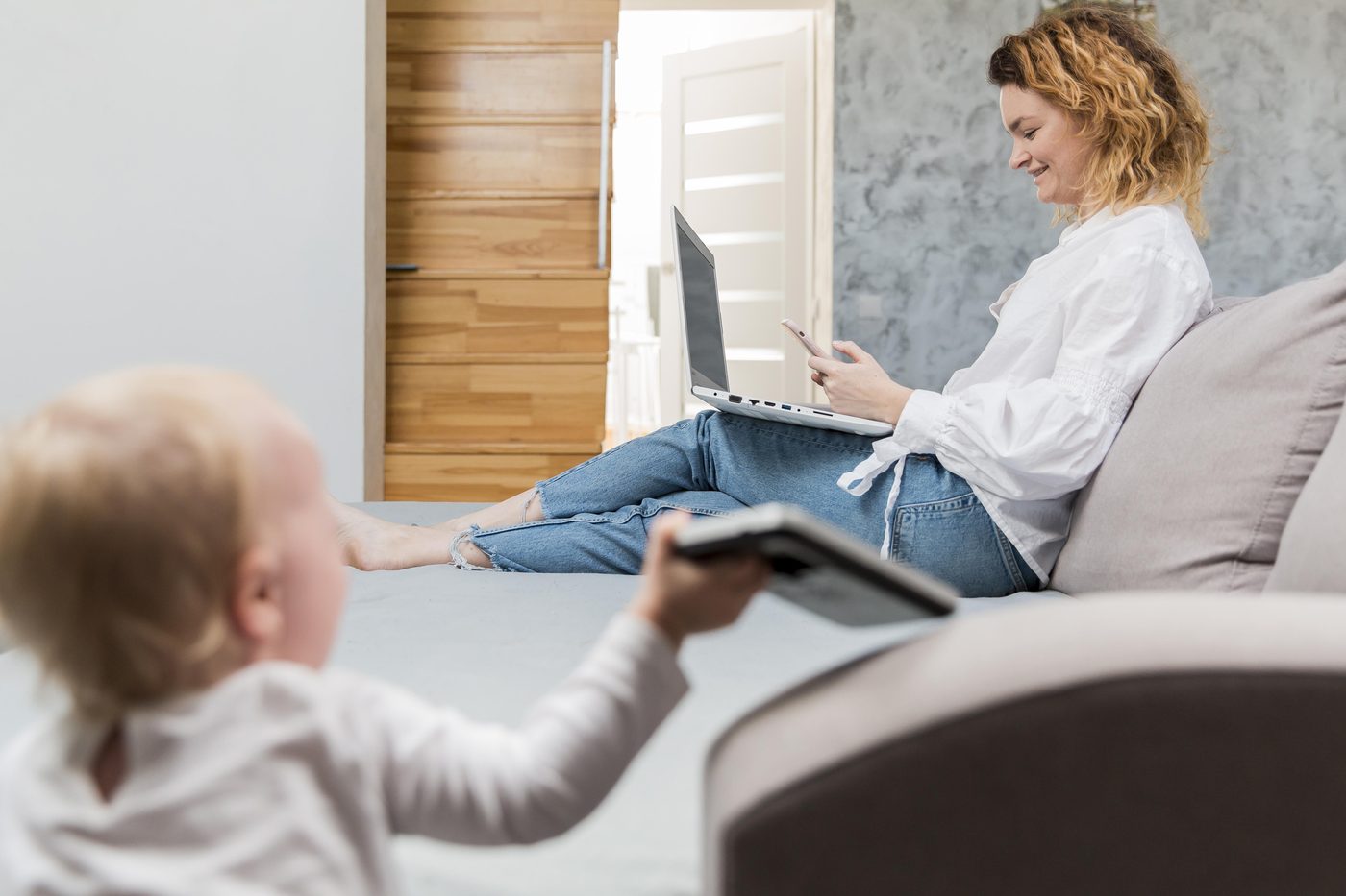 Părinte care caută informații pe laptop, acasă, cu copilul alături