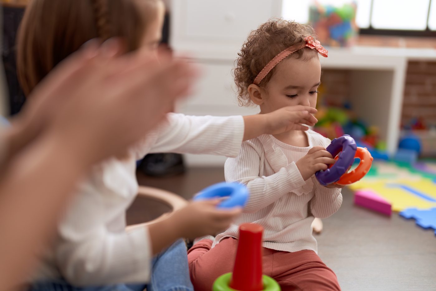 Copil mic care manevrează inele colorate, în timpul jocului